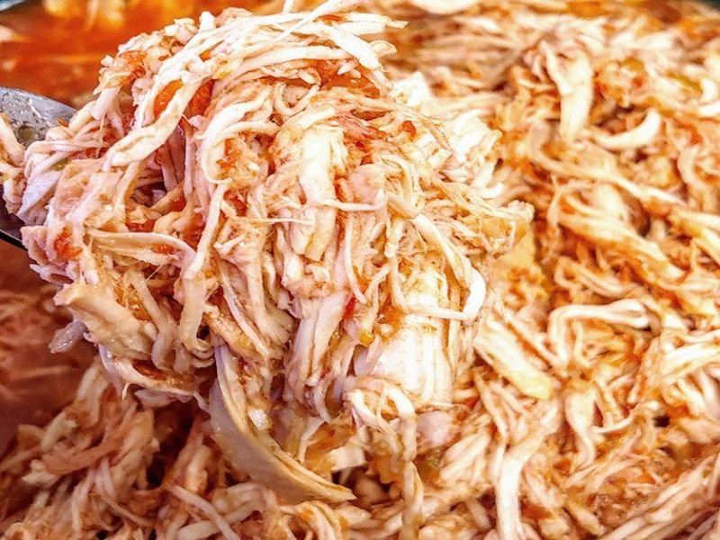 Freshly shredded chicken pulled apart with forks